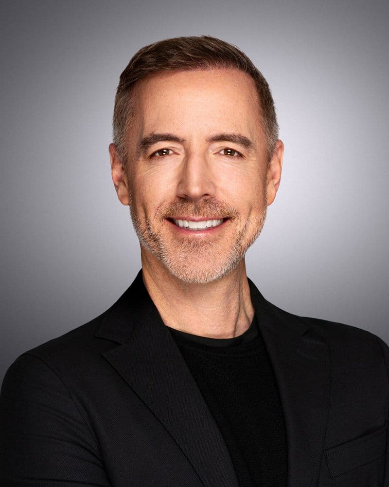 Reeve Collins, studio headshot on a gray background